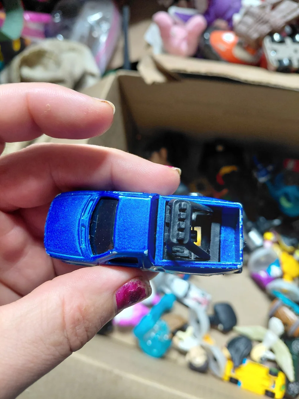 blue diecast pickup truck is a 1:64 scale model, possibly from a 